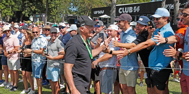 LIV CEO and commissioner Greg Norman high fives the fans as he walks to the first tee during the final round of the LIV Golf Invitational Series Chicago at Rich Harvest Farms in Sugar Grove, Illinois. 