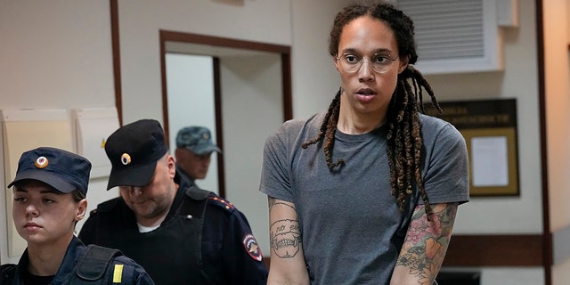 FILE - WNBA star and two-time Olympic gold medalist Brittney Griner is escorted from a court room ater a hearing, in Khimki just outside Moscow, Russia, Aug. 4, 2022.