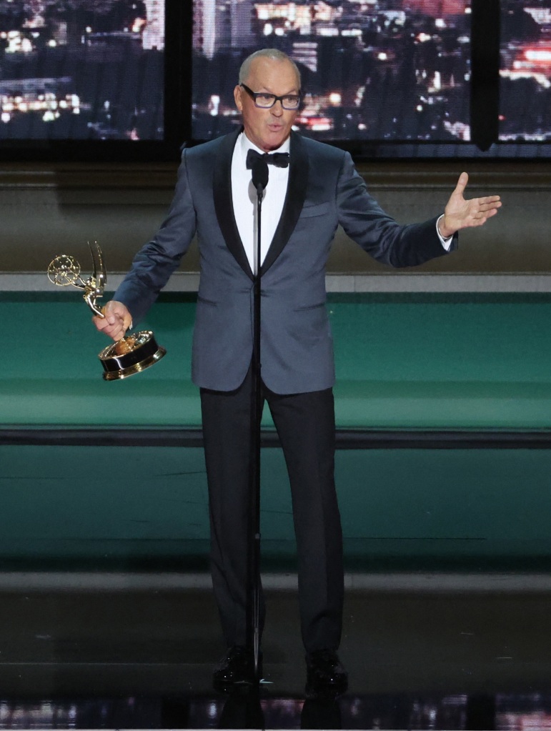 Michael Keaton onstage holding an Emmy. 