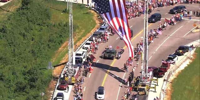 Americans crowd line the highway as a funeral procession for Jared drives by in Missouri.