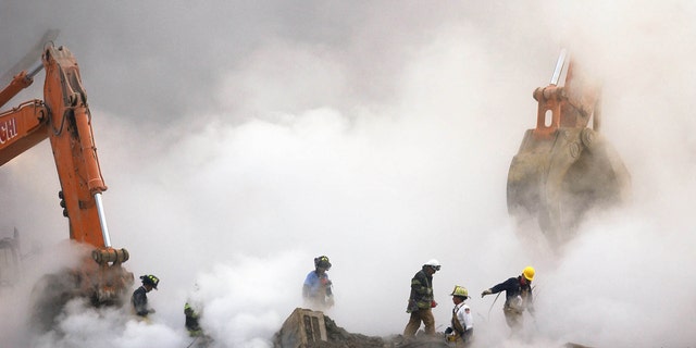 Firefighters make their way over the ruins of the World Trade Center through clouds of smoke Oct. 11, 2001, in New York City. Nearly 3,000 people were killed when al Qaeda terrorists hijacked four planes on Sept. 11, 2001.