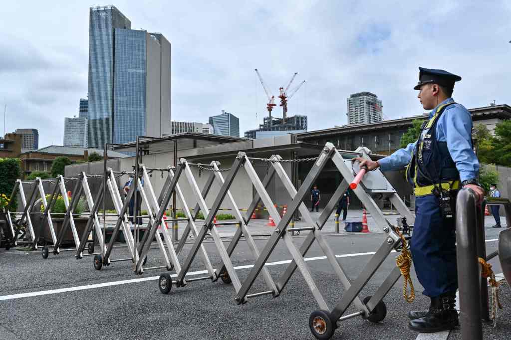 Police stand guard near the site where the man set himself on fire in Tokyo on Sept. 21, 2022