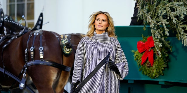 First lady Melania Trump stands next to the 2020 official White House Christmas tree as it is presented on the North Portico of the White House Nov. 23, 2020, in Washington. 