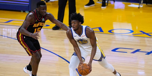 Golden State Warriors center James Wiseman (33) moves the ball past Atlanta Hawks center Clint Capela (15) during the first half of an NBA basketball game in San Francisco, Friday, March 26, 2021. (AP Photo/Tony Avelar)