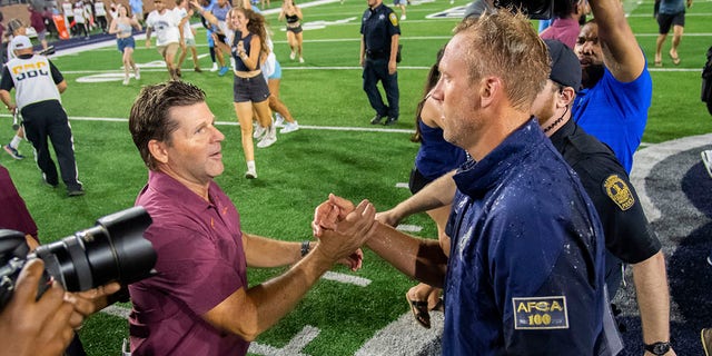 Old Dominion coach Ricky Rahne, right, shakes hands with Virginia Tech coach Brent Pry after Old Dominion's win Friday, Sept. 2, 2022, in Norfolk, Va. 