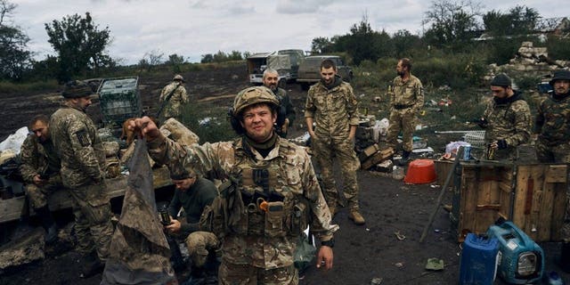 A Ukrainian soldier holds up a dirty Russian flag in Izium, Kharkiv region, Ukraine, Tuesday, Sept. 13, 2022.