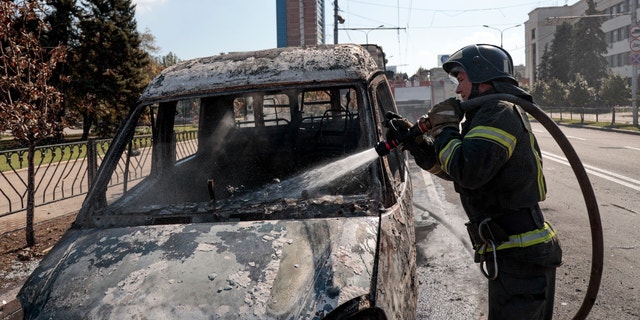 A firefighter extinguishes a burning vehicle after shelling in Donetsk, area controlled by Russian-backed separatist forces, eastern Ukraine, Saturday, Sept. 17, 2022. A Ukrainian shelling attack killed four people in downtown Donetsk on Saturday. According to the city's Mayor Alexey Kulemzin, fragments of munitions for Caesar howitzers were found. 