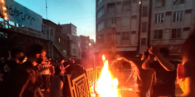 Protesters make fire and block the street during a protest over the death of a woman who was detained by the morality police, in downtown Tehran, Iran. 