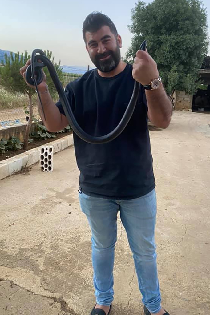 Al-Saii during happier time playing with a snake. So desperate was he to withdraw his savings that he spent 17 days in jail after threatening to burn down his local bank branch. 