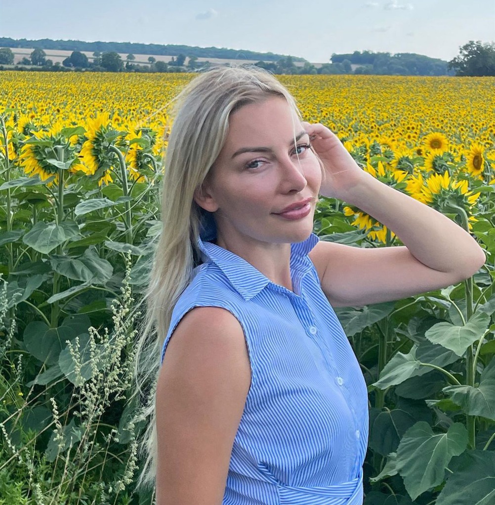anna bey posing in front of field of sunflowers
