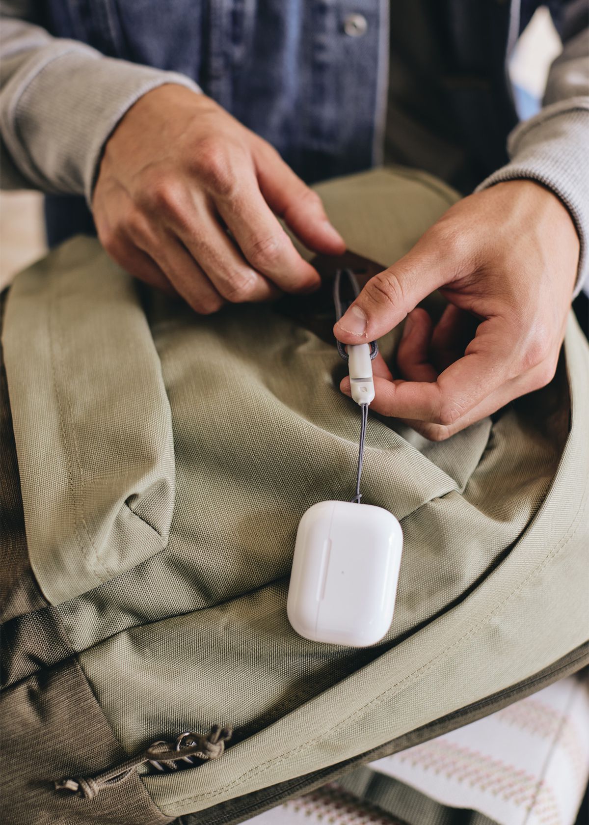 A person holds a lanyard that has a pair of AirPods Pro attached on the end.