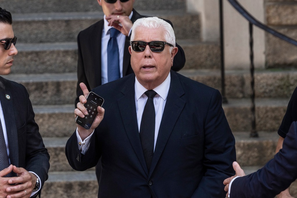 Dennis Basso wearing an all-black suit and sun glasses.