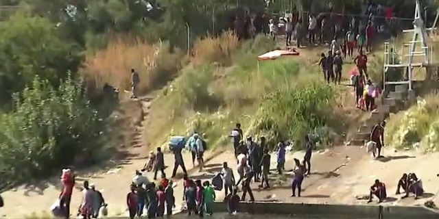 Migrants cross the Rio Grande river