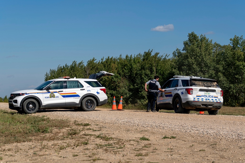 Law enforcement personnel guard a roadblock set up on the James Smith Cree First Nation reservation in Saskatchewan on Sep. 6, 2022.