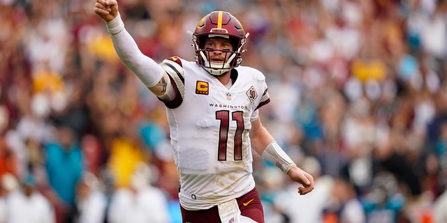 Washington Commanders quarterback Carson Wentz (11) reacting to making a two-point conversion against the Jacksonville Jaguars in the closing minutes of the second half of a game Sept. 11, 2022, in Landover, Md.