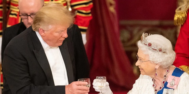 Britain's Queen Elizabeth II raised a glass with US President Donald Trump during a state banquet in the ballroom at Buckingham Palace on June 3, 2019 (DOMINIC LIPINSKI//GETTY IMAGES)