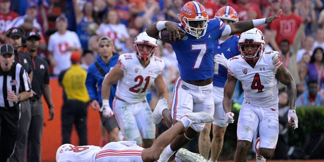 Florida running back Trevor Etienne leaps over Utah safety Cole Bishop Saturday, Sept. 3, 2022, in Gainesville.