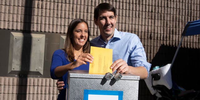 Democratic candidate for California's 10th Congressional District Josh Harder and his wife, Pam Harder, place Pam's ballot inside a ballot box at a polling station on Nov. 6, 2018 in Modesto, California.