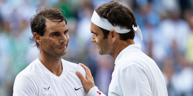 Roger Federer of Switzerland, right, shakes hands with Rafael Nadal of Spain after defeating him in a men's singles semifinal at Wimbledon July 12, 2019, in London.  