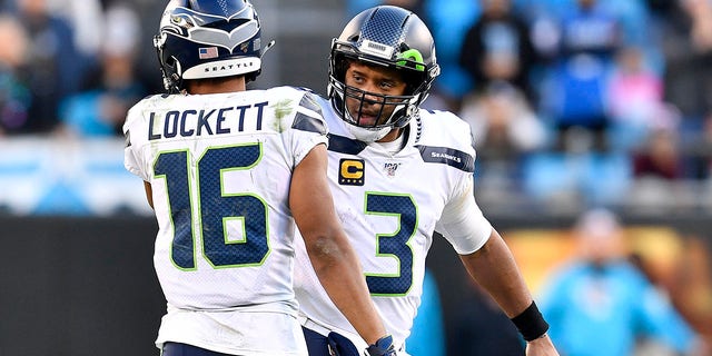 Russell Wilson (3) encourages Tyler Lockett of the Seattle Seahawks during the fourth quarter against the Carolina Panthers at Bank of America Stadium on Dec. 15, 2019, in Charlotte, North Carolina.