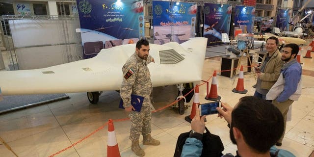 A member of the Iran's Revolutionary Guard Corps, poses for a photograph with Shahed-171 (Simorgh) Drone during the Defensive Achievements Exhibition of the 40th anniversary of the Islamic Revolution in Imam Khomeini Grand Mosque in central Tehran on the second day of ten-day celebration of Islamic Revolution anniversary, February 2, 2019.  