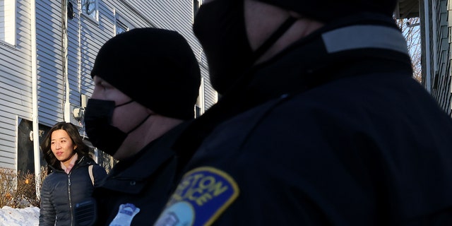 Boston Mayor Michelle Wu is met by police officers as she leaves her home where several protesters had gathered outside to demonstrate against her vaccine mandate in Boston's Roslindale on Jan. 12, 2022. 