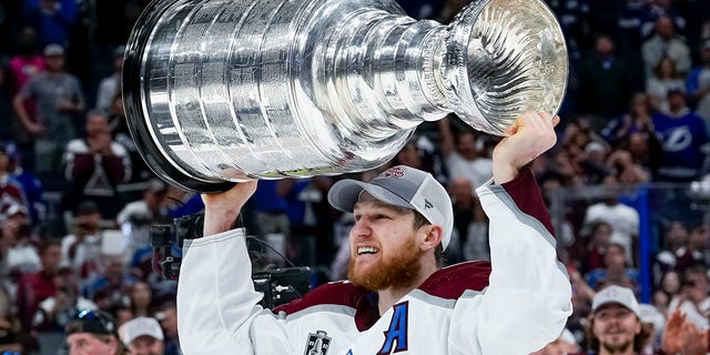 Colorado Avalanche center Nathan MacKinnon hoisting the Stanley Cup after Game 6 of the Stanley Cup Finals against the Tampa Bay Lightning June 26th, 2022, at Amalie Arena in Tampa, Fla.