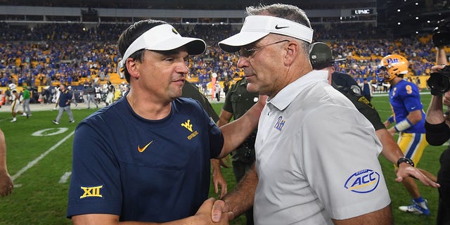 Pittsburgh Panthers head coach Pat Narduzzi shakes hands with West Virginia Mountaineers head coach Neal Brown at the conclusion of the game at Acrisure Stadium in Pittsburgh on Thursday, Sept. 1, 2022.