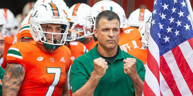 Miami Hurricanes head coach Mario Cristobal and wide receiver Xavier Restrepo (7) prepare to take the field for the start of a game against the Bethune Cookman Wildcats at Hard Rock Stadium in Miami Gardens, Fla., Sept. 3, 2022. 