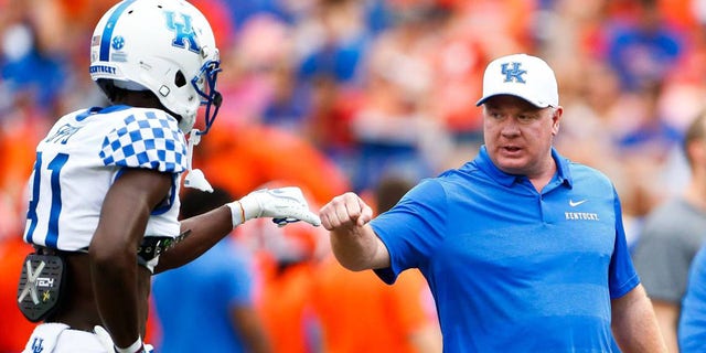 Kentucky coach Mark Stoops fist bumps wide receiver Tavin Richardson before Kentucky's 27-16 win at Florida in 2018.  