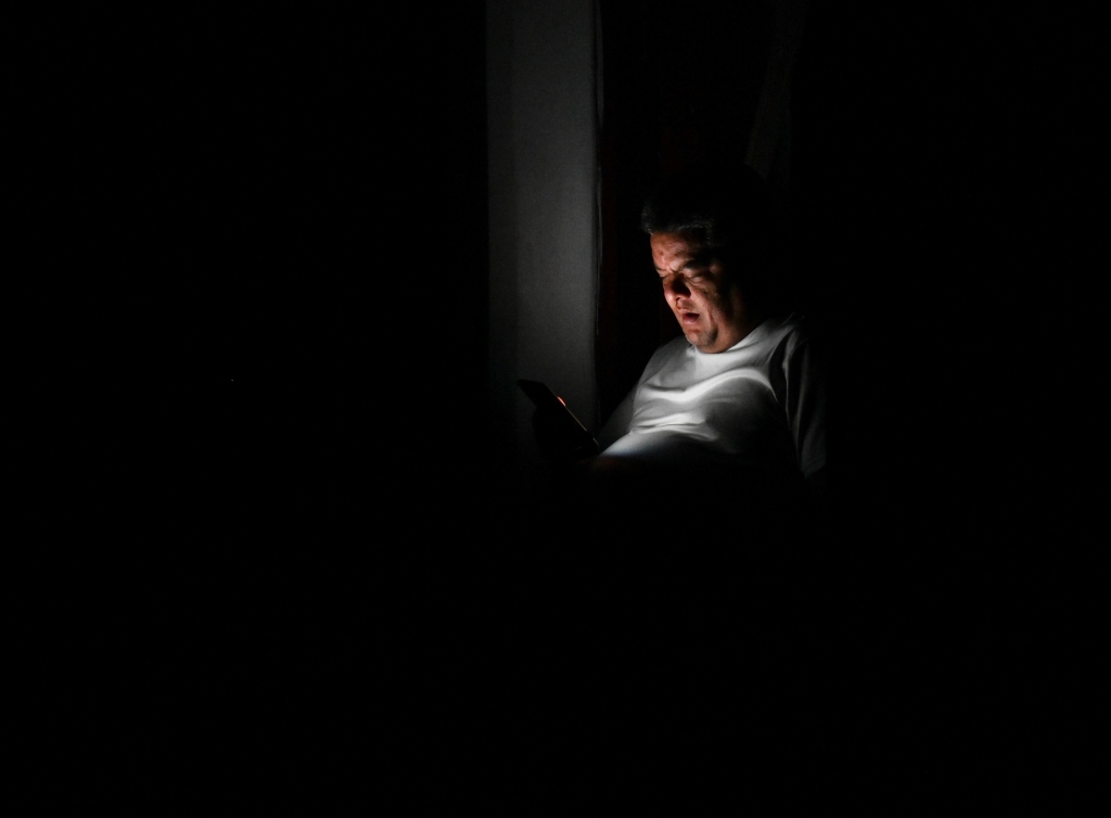 A man is spotted on his phone in the middle of a street in Havana during the blackout on Sept. 27, 2022.