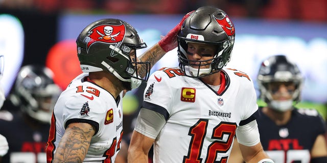 Tom Brady (12) of the Tampa Bay Buccaneers celebrates with Mike Evans after a touchdown against the Atlanta Falcons at Mercedes-Benz Stadium in Atlanta on Dec. 5, 2021.