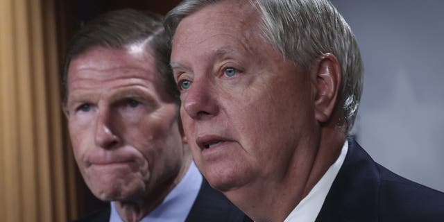 Sen. Richard Blumenthal, D-Conn., listens as Sen. Lindsey Graham speaks during a press conference at the U.S. Capitol, May 10, 2022, in Washington.