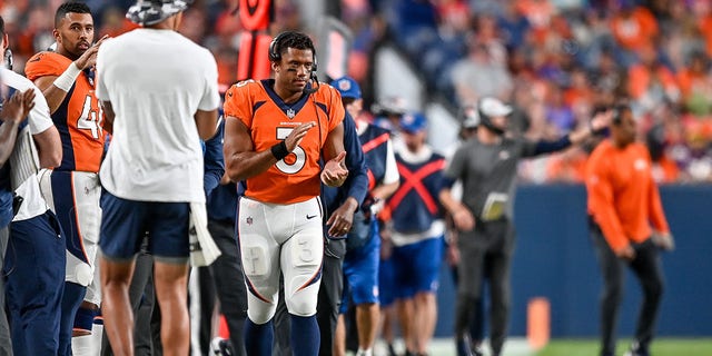 Quarterback Russell Wilson, #3 of the Denver Broncos, watches the game with a headset on during a preseason NFL game against the Minnesota Vikings at Empower Field at Mile High on August 27, 2022, in Denver.