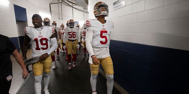 Deebo Samuel, left, and Trey Lance of the San Francisco 49ers head to the field before a game against the Houston Texans at NRG Stadium in Houston, Texas, on Aug. 25, 2022.