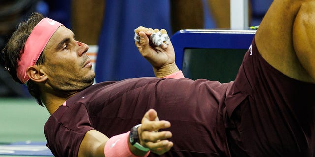 Rafael Nadal, of Spain, lies down to receive medical treatment on his nose after hitting himself with his own racket during his match against Fabio Fognini, of Italy, in the second round of the men's singles at the US Open at the USTA Billie Jean King National Tennis Center on September 01, 2022 in New York City.