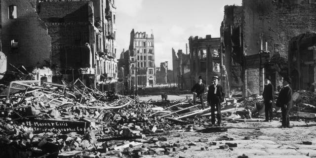 People standing in the rubble of collapsed buildings on Mason and Ellis Streets after the earthquake and fire of April 18, 1906, in San Francisco, California.