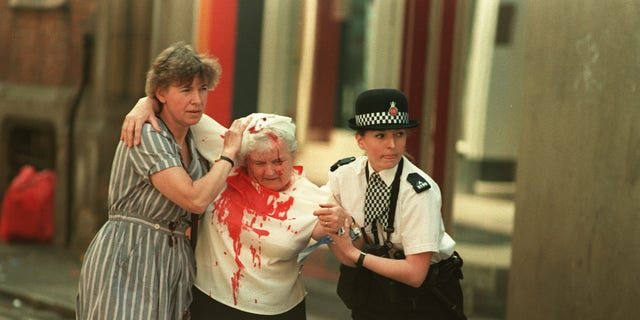 Officer Vanessa Winstanley, (right), 23, from Wigan, and another woman help an elderly injured woman away from Manchester city centre after an IRA bomb exploded in the city's main shopping area. 