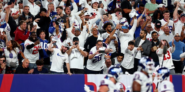 Fans celebrate after Saquon Barkley #26 of the New York Giants celebrates scored a 36 yard touchdown against the Dallas Cowboys during the third quarter in the game at MetLife Stadium on September 26, 2022 in East Rutherford, New Jersey.