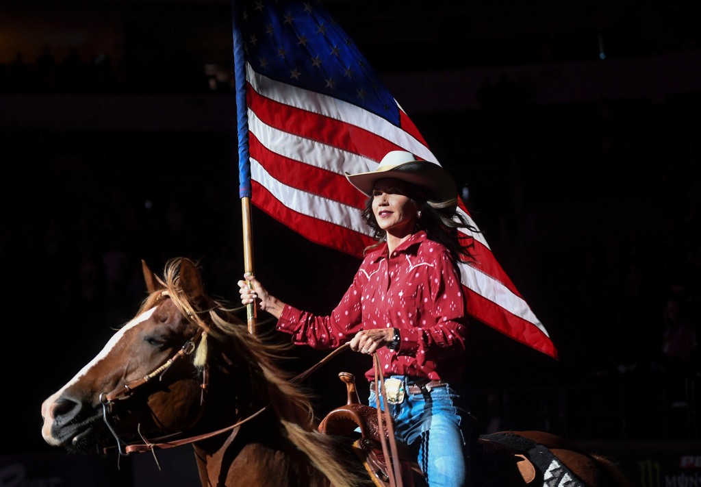 Gov. Kristi Noem presents a United States flag before the national anthem is played at the Professional Bull Riders competition Saturday, July 11, 2020.