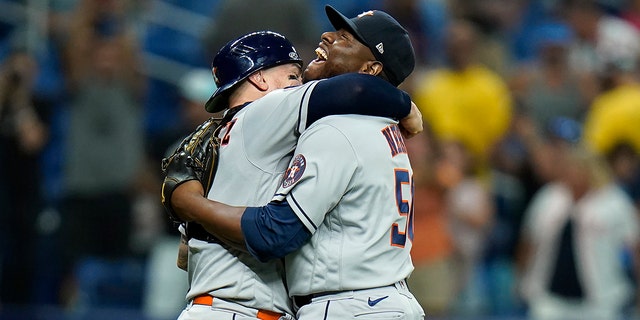 Houston Astros relief pitcher Hector Neris (50) hugs catcher Christian Vazquez after the team defeated the Tampa Bay Rays during a baseball game Monday, Sept. 19, 2022, in St. Petersburg, Fla. 