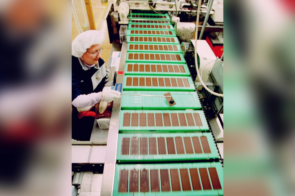 Barb Weidman checks chocolate Hershey bars traveling on a conveyor belt at the factory in Hershey, Pa., Monday, April 24, 2000.