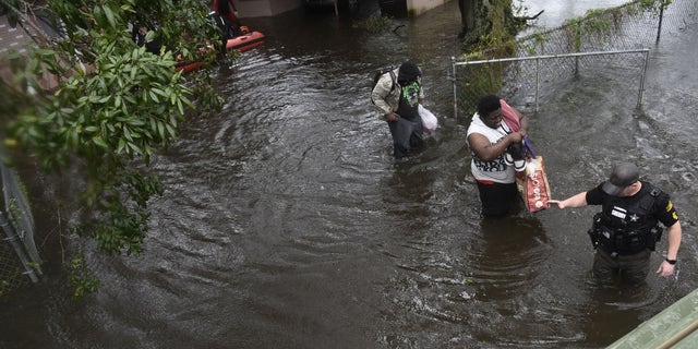 People make their way through flooded areas in central Florida from Hurricane Ian.