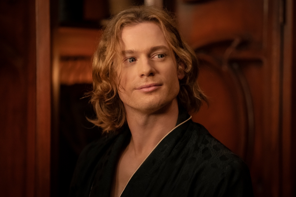 Sam Reid as Lestat in "Interview with the Vampire." His eyes are glowing like a vampire's eyes and he's looking off-camera and wearing a black robe.