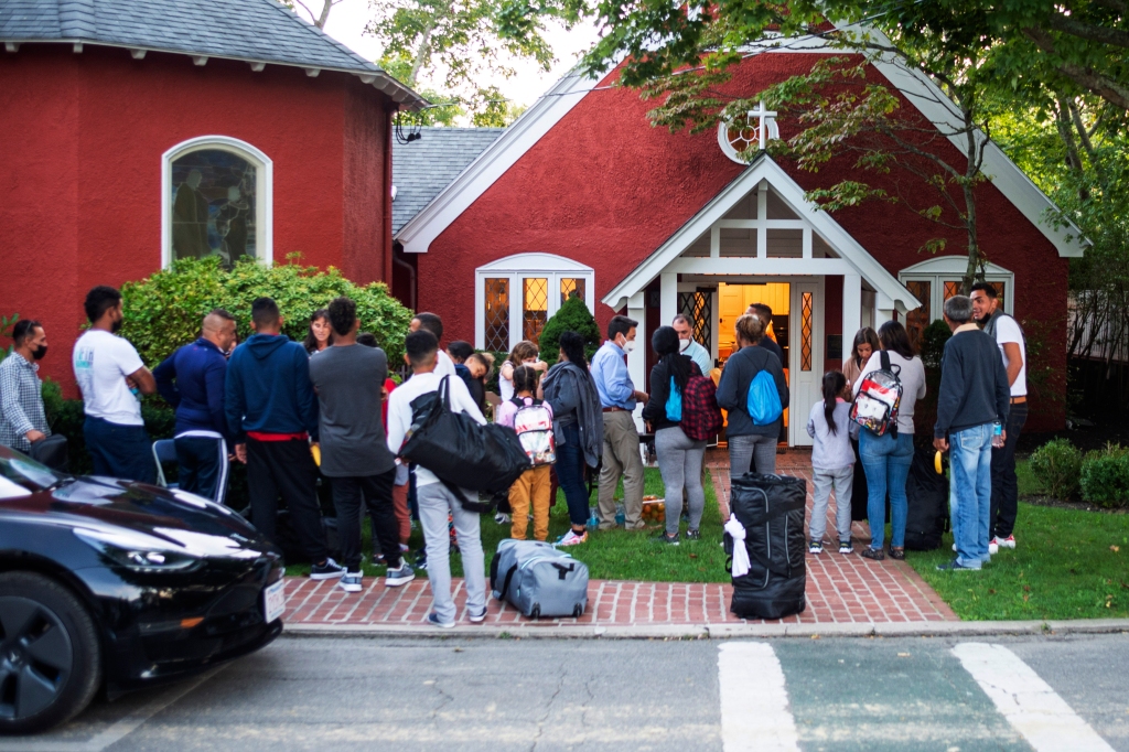 Immigrants gather with their belongings outside St. Andrews Episcopal Church in Edgartown, Mass. in Martha's Vineyard.