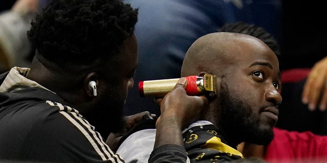 A fan gets a haircut as Nick Kyrgios, of Australia, plays Karen Khachanov, of Russia, during the quarterfinals of the U.S. Open tennis championships, Tuesday, Sept. 6, 2022, in New York.