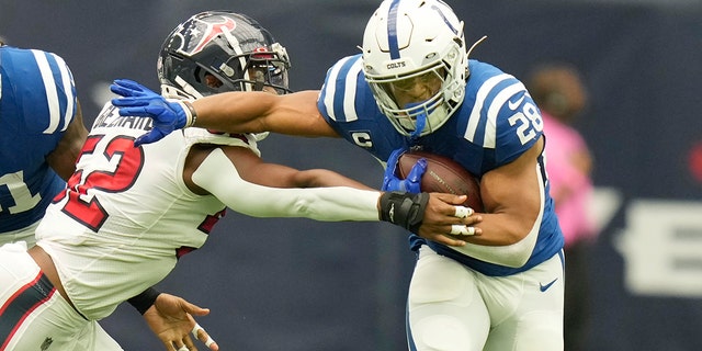 Indianapolis Colts running back Jonathan Taylor (28) stiff arms Houston Texans defensive end Jonathan Greenard (52) during the first half Sept. 11, 2022, in Houston.