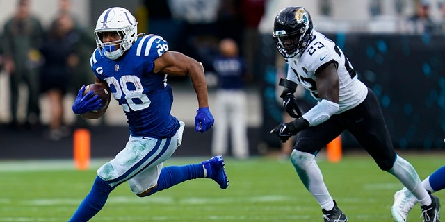 Indianapolis Colts running back Jonathan Taylor (28) get past Jacksonville Jaguars linebacker Foyesade Oluokun (23) for a gain during the second half of an NFL football game, Sunday, Sept. 18, 2022, in Jacksonville, Fla. 