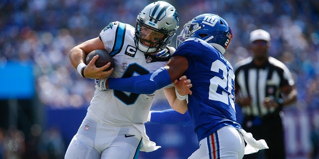 New York Giants' Julian Love, right, tries to tackle Carolina Panthers quarterback Baker Mayfield during the first half an NFL football game, Sunday, Sept. 18, 2022, in East Rutherford, New Jersey. 