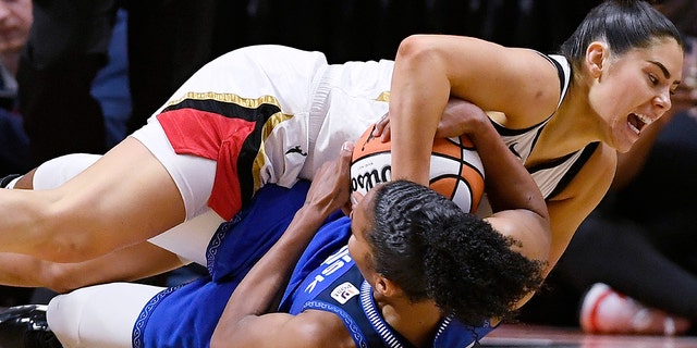 Las Vegas Aces' Kelsey Plum, top, and Connecticut Sun's Alyssa Thomas fight for possession of the ball during the second half of Game 4 of the WNBA Finals in Uncasville, Connecticut, on Sept. 18, 2022.